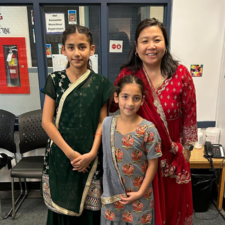Two students and a teacher dressed in traditional attire to celebrate Diwali